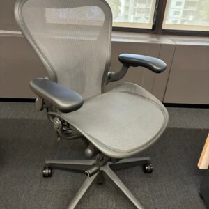 A used Herman Miller Aeron ergonomic office chair featuring an 8Z Pellicle mesh back and seat, PostureFit SL sacral and lumbar support, adjustable arms, and a polished aluminum five-star base.