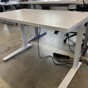 A used Fully Jarvis electric standing desk featuring a smooth, rectangular worksurface and a sturdy, height-adjustable steel frame with a programmable memory handset.